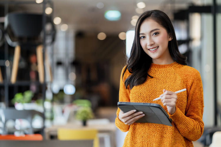 タブレットを持ちながら微笑む女性